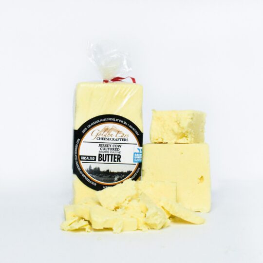 Block of yellow shea butter with packaging and chunks.