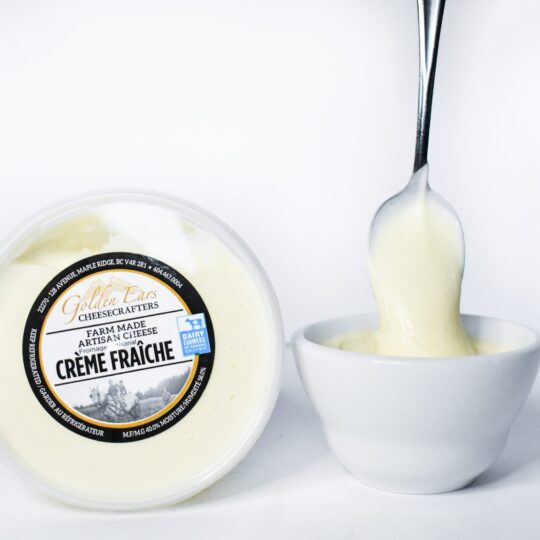 Creamy Crème Fraîche being poured into a white bowl.